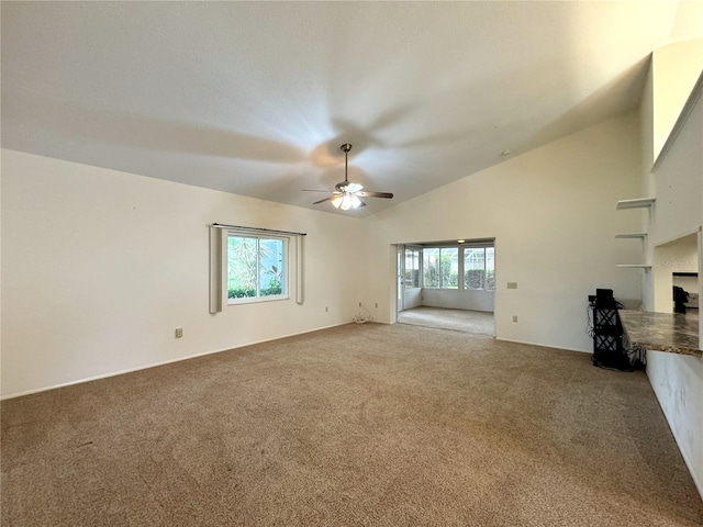 unfurnished living room featuring carpet flooring, ceiling fan, a fireplace, and vaulted ceiling