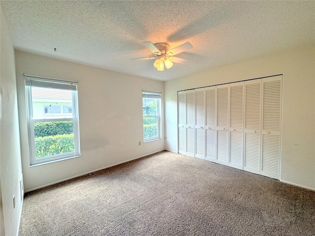 unfurnished bedroom featuring a closet, ceiling fan, a textured ceiling, and carpet floors