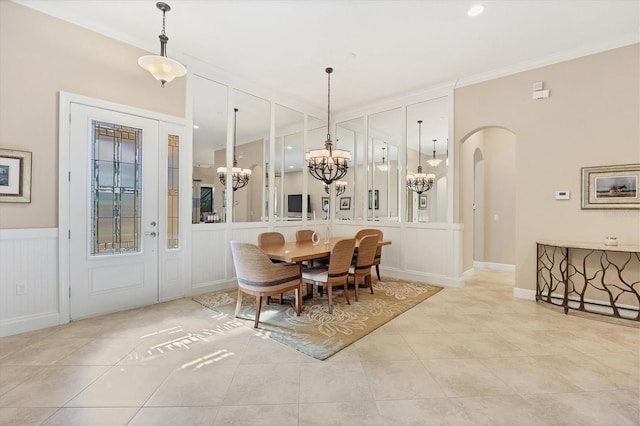 tiled dining area featuring crown molding and a chandelier