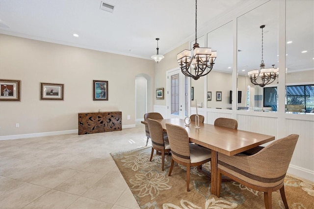 tiled dining space featuring a chandelier and ornamental molding