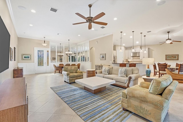 living room with ceiling fan, light tile patterned flooring, and ornamental molding