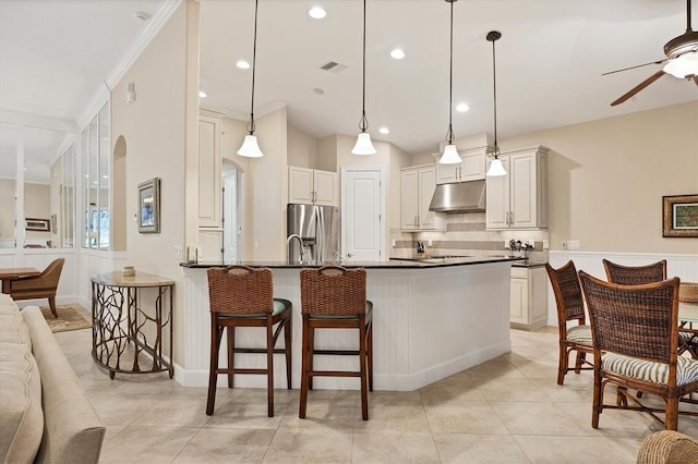 kitchen with a kitchen breakfast bar, stainless steel fridge, kitchen peninsula, and ceiling fan