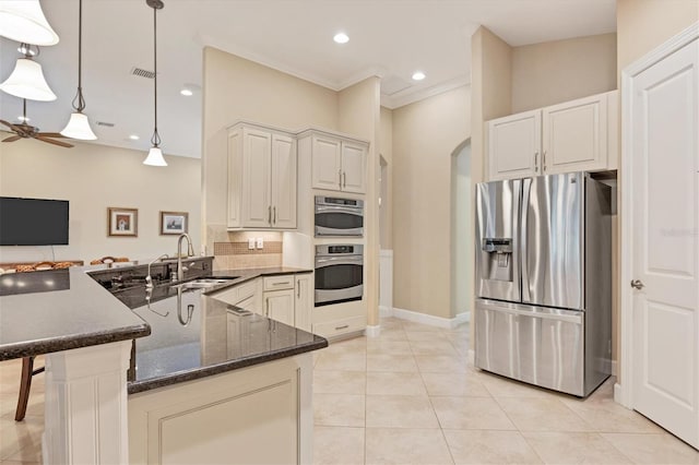 kitchen featuring appliances with stainless steel finishes, decorative light fixtures, sink, kitchen peninsula, and ceiling fan