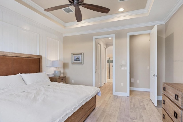 bedroom with ceiling fan, crown molding, light hardwood / wood-style flooring, and a tray ceiling