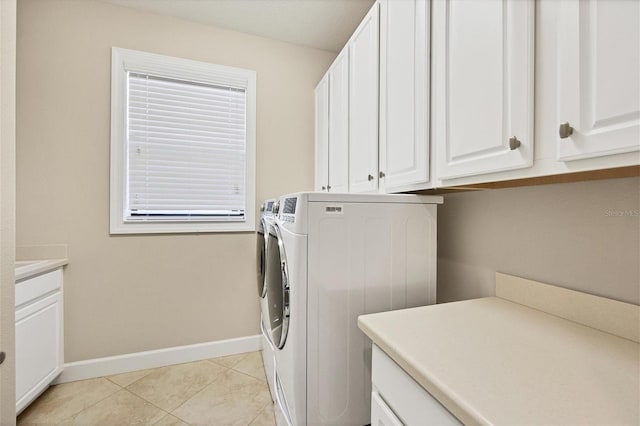 laundry area featuring cabinets, separate washer and dryer, and light tile patterned floors