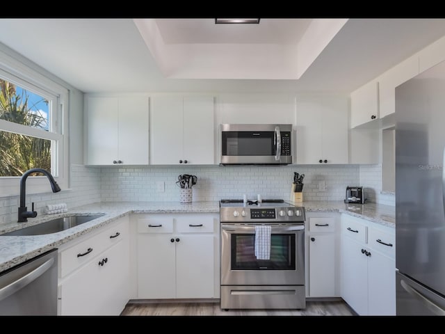 kitchen featuring appliances with stainless steel finishes, white cabinets, and sink