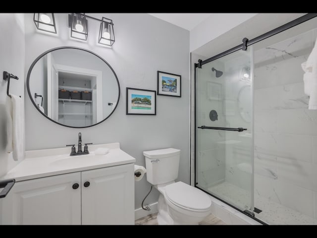 bathroom with vanity, walk in shower, and toilet