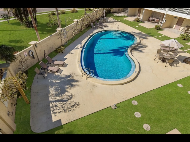 view of pool with a lawn and a patio area