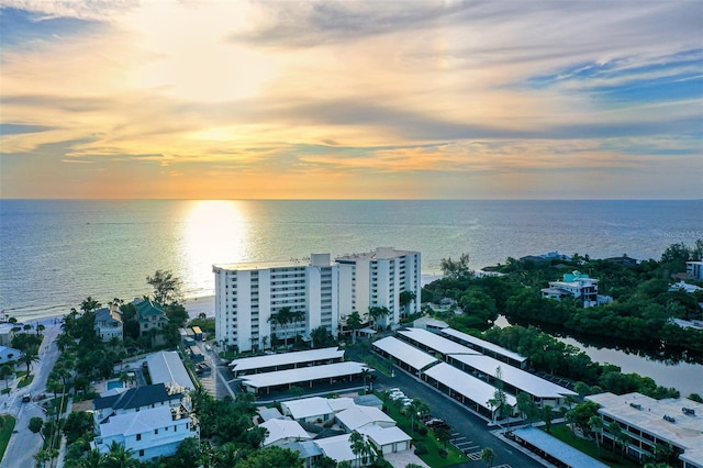 aerial view at dusk featuring a water view