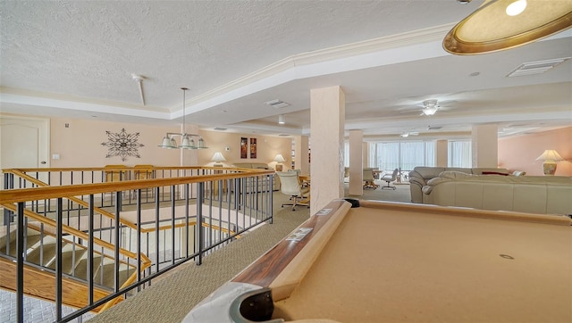 recreation room featuring pool table, a textured ceiling, a tray ceiling, ceiling fan, and ornamental molding