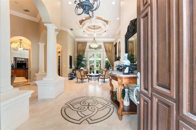 foyer entrance featuring arched walkways, a high ceiling, french doors, decorative columns, and crown molding