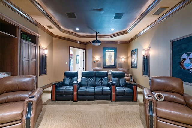 cinema with visible vents, ornamental molding, a tray ceiling, and light colored carpet