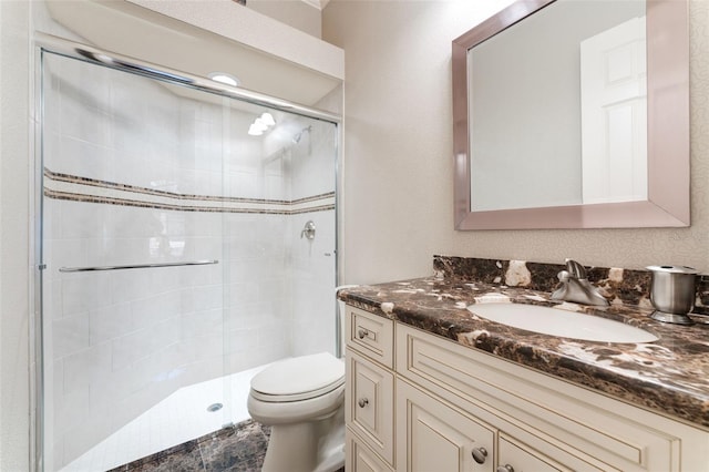 bathroom with a shower with shower door, toilet, and vanity