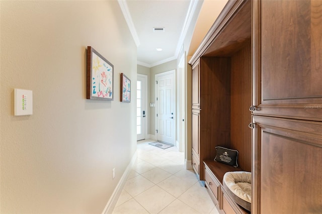 hallway with ornamental molding and light tile patterned floors