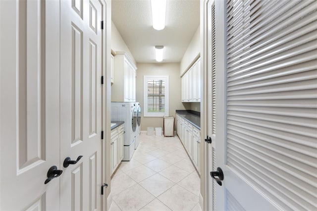 washroom featuring light tile patterned floors, separate washer and dryer, and cabinets