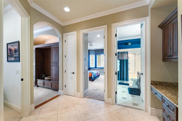 interior space with ceiling fan, crown molding, and light tile patterned flooring