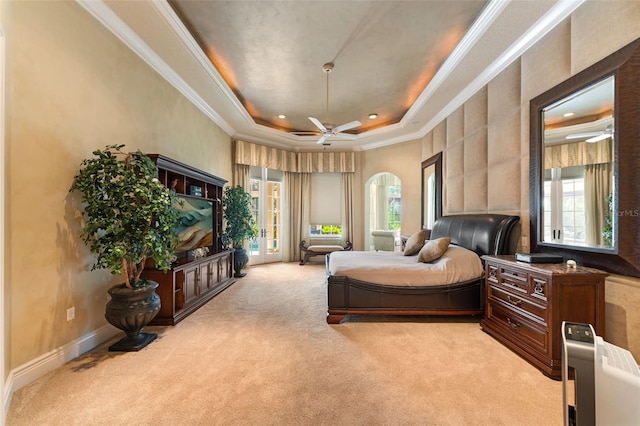 carpeted bedroom with multiple windows, a tray ceiling, and ornamental molding