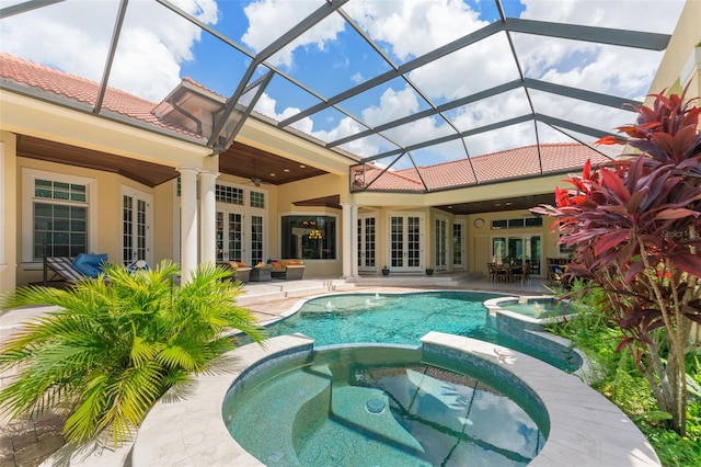 view of pool with glass enclosure, french doors, an in ground hot tub, ceiling fan, and a patio