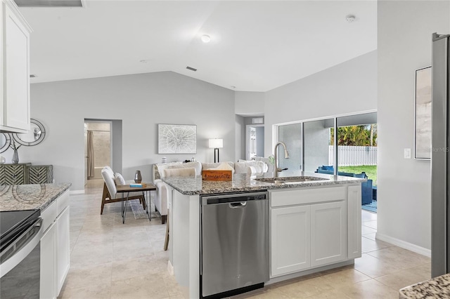 kitchen with lofted ceiling, stainless steel dishwasher, white cabinetry, light tile patterned floors, and sink