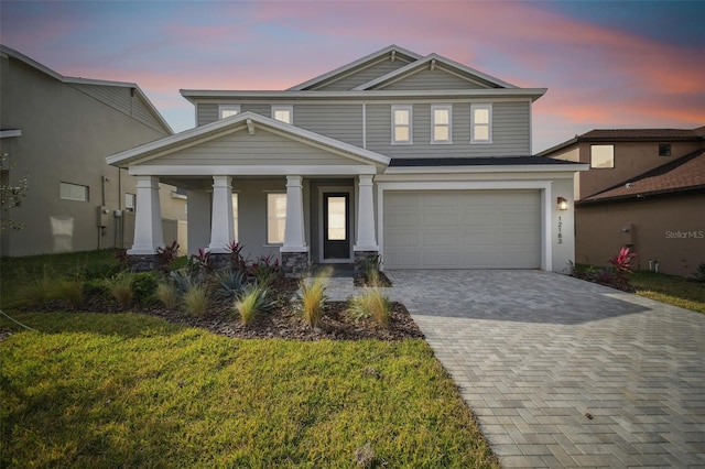 view of front of home with a garage and a lawn