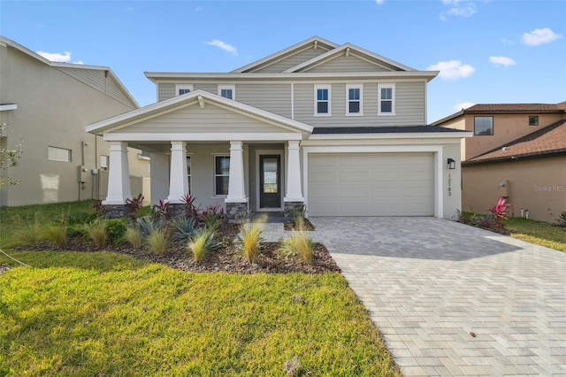 view of front facade featuring a front yard, a porch, and a garage