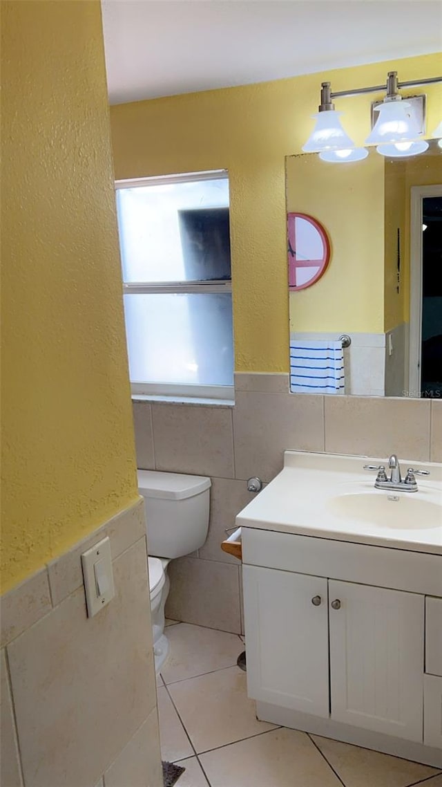 bathroom with vanity, tile walls, tile patterned flooring, and toilet