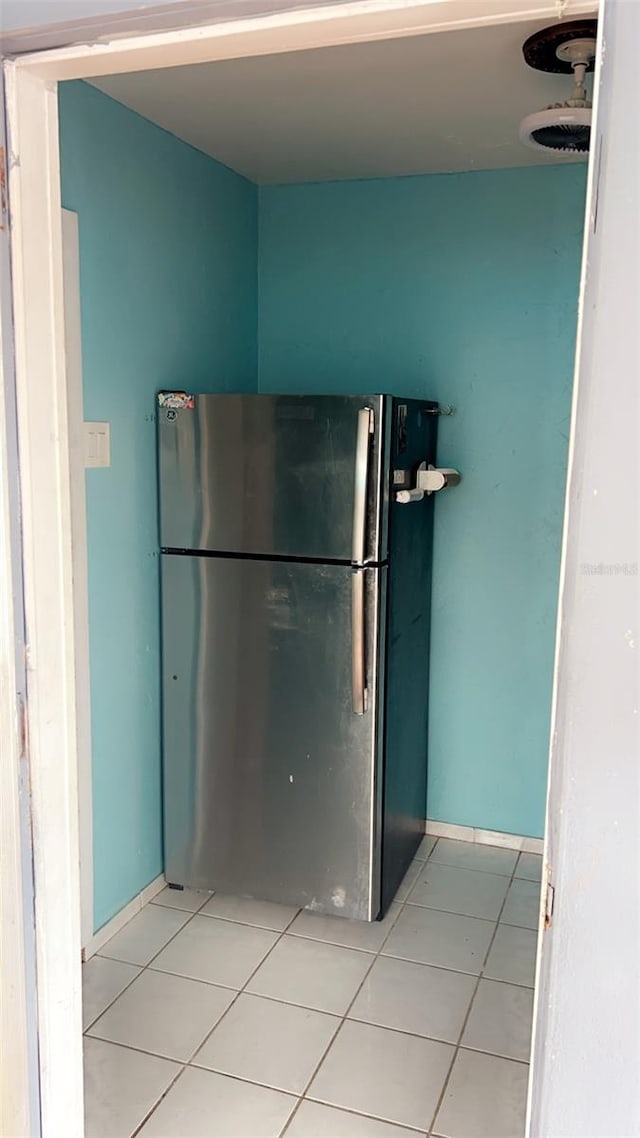 kitchen featuring light tile patterned flooring and stainless steel refrigerator