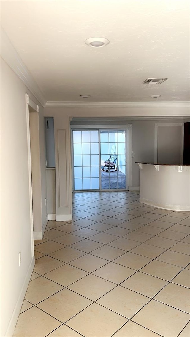 interior space with light tile patterned floors and ornamental molding