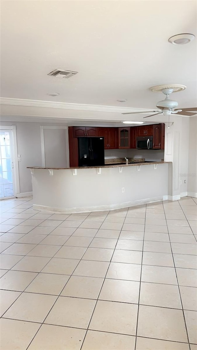 kitchen with a kitchen breakfast bar, black refrigerator with ice dispenser, and light tile patterned floors