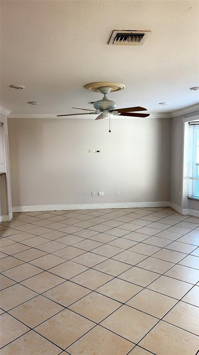 tiled spare room featuring ornamental molding and ceiling fan