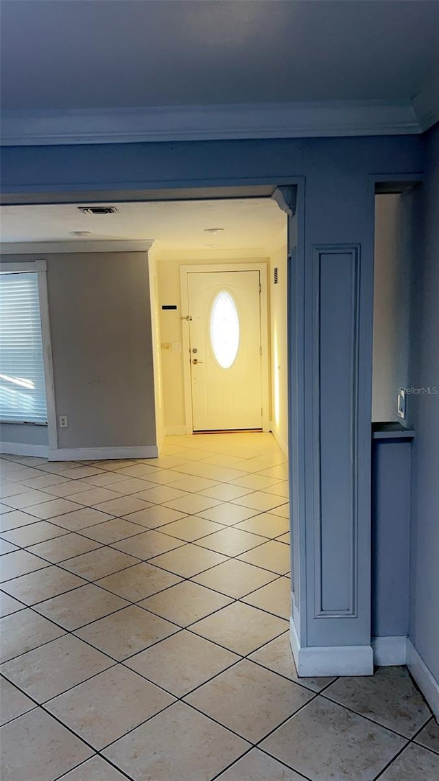 interior space featuring ornamental molding and light tile patterned floors