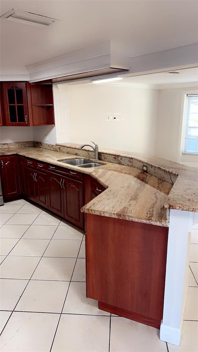 kitchen featuring light tile patterned flooring, light stone countertops, sink, and kitchen peninsula