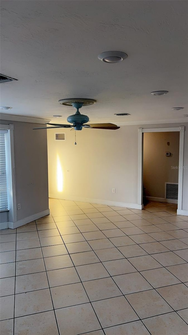 tiled spare room with ceiling fan