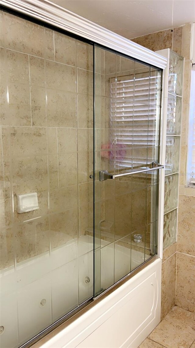 bathroom featuring shower / bath combination with glass door