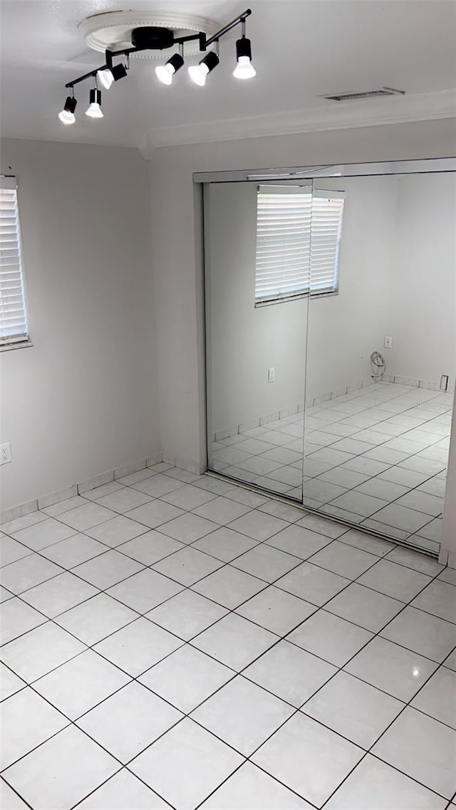 interior space with light tile patterned flooring and rail lighting