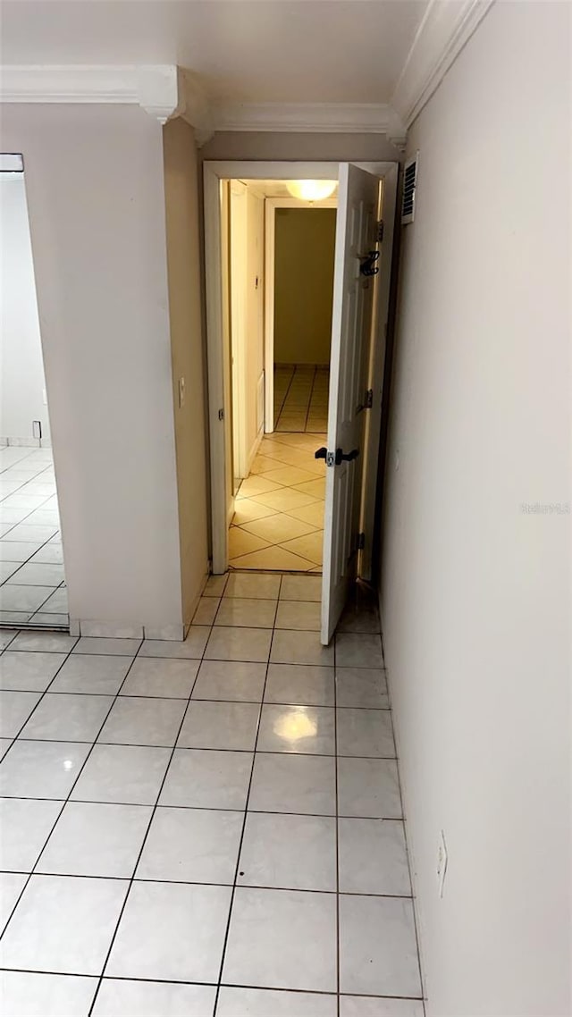 hall featuring ornamental molding and light tile patterned flooring