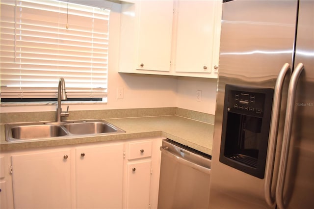 kitchen featuring stainless steel appliances, sink, and white cabinets