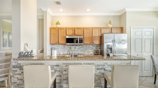 kitchen with light stone countertops, tasteful backsplash, light tile patterned floors, stainless steel appliances, and kitchen peninsula