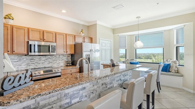 kitchen with stainless steel appliances, decorative light fixtures, decorative backsplash, light tile patterned floors, and a kitchen breakfast bar