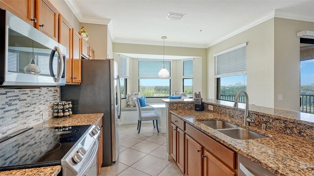 kitchen featuring sink, stove, tasteful backsplash, and a healthy amount of sunlight