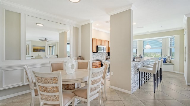 dining room featuring light tile patterned floors, ornamental molding, and ceiling fan