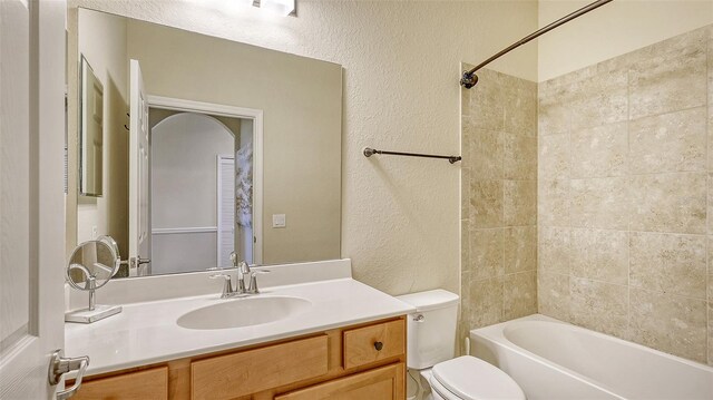 full bathroom with tiled shower / bath, toilet, and vanity