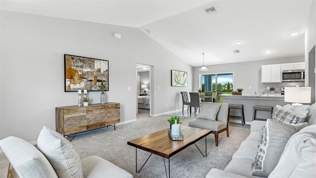 carpeted living room featuring sink and lofted ceiling