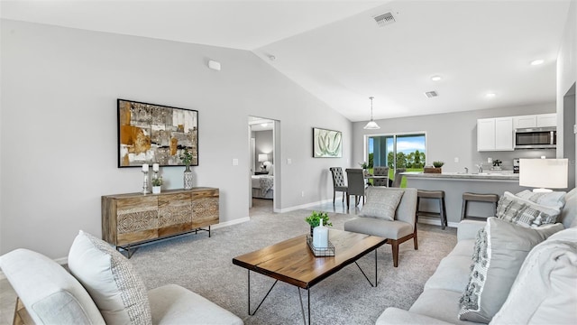 living room with sink, vaulted ceiling, and light colored carpet