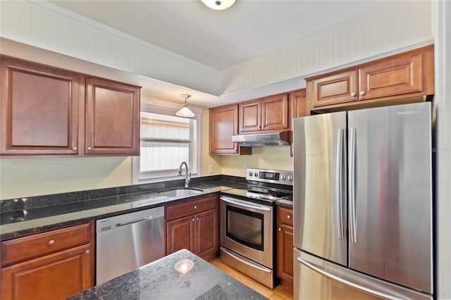 kitchen featuring appliances with stainless steel finishes, a sink, under cabinet range hood, and ornamental molding