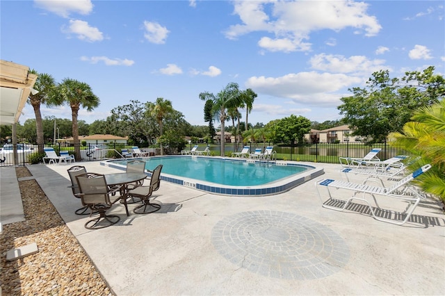 pool with a patio area and fence