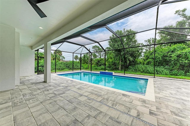 view of pool featuring glass enclosure and a patio area