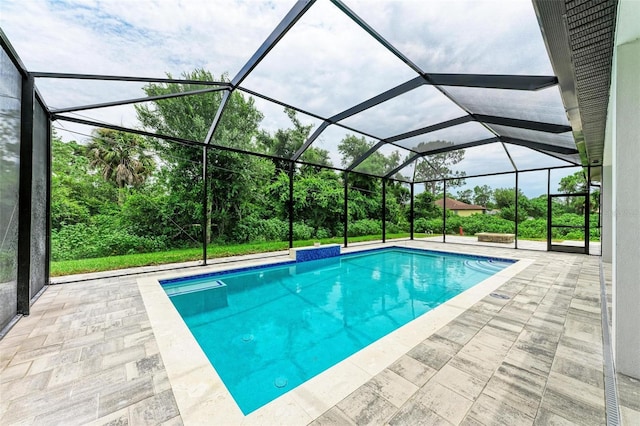 view of pool with a patio and glass enclosure