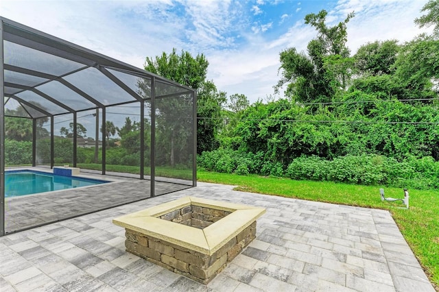 view of swimming pool with a yard, a lanai, a patio area, and a fire pit