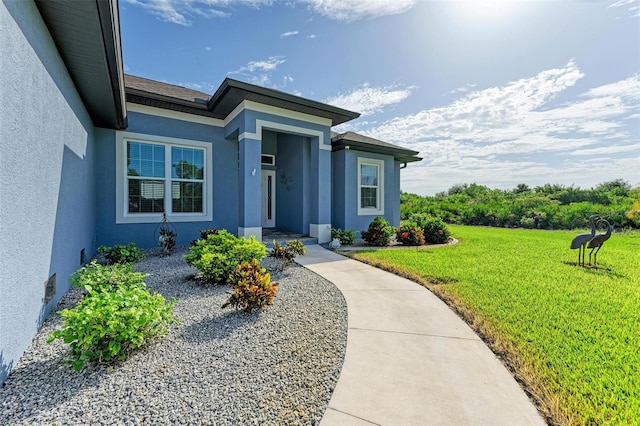 view of exterior entry with a lawn